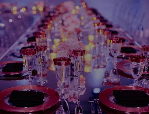 Faded background image of a nicely decorated table with lots of red glassware into the horizon.