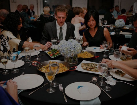 A group of people sitting around a circle table having a nice dinner.