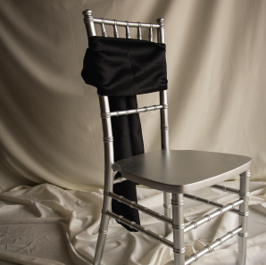 Front of a black chair sash tied into a bow on a silver chair.