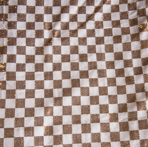 Close up of a champagne and gold checkered sequin tablecloth.