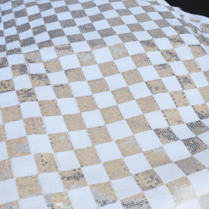 Close up of a champagne and gold checked table runner.