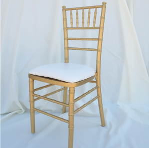 Gold colored Chiavari chair in front of  a white backdrop.