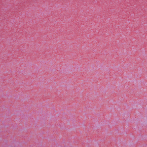 Close up of a coral colored sequin tablecloth.
