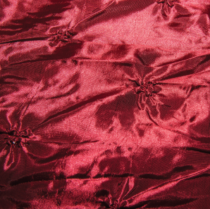 Close up of a pinched crimson red tablecloth.