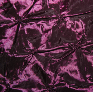 Close up of an eggplant colored pinched tablecloth.