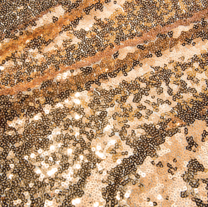 Close up of a gold colored sequined tablecloth.