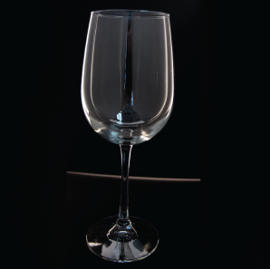 Close up of a large wine glass in front of a black backdrop.