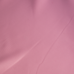 Close up of a light pink polyester tablecloth.