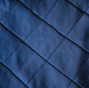 Close up of a navy blue tuck tablecloth.