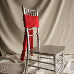 Front of a red chair sash tied into a bow on a silver chair.