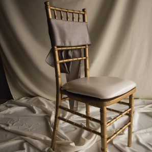 Front of a silver colored chair sash tied into a bow on a silver chair.