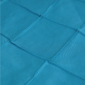 Close up of a turquoise pin tuck tablecloth.