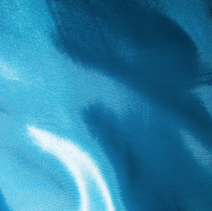 Close up of a turquoise colored silk tablecloth.