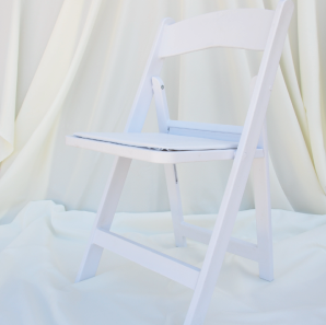 White resin garden chair in front of a white backdrop.